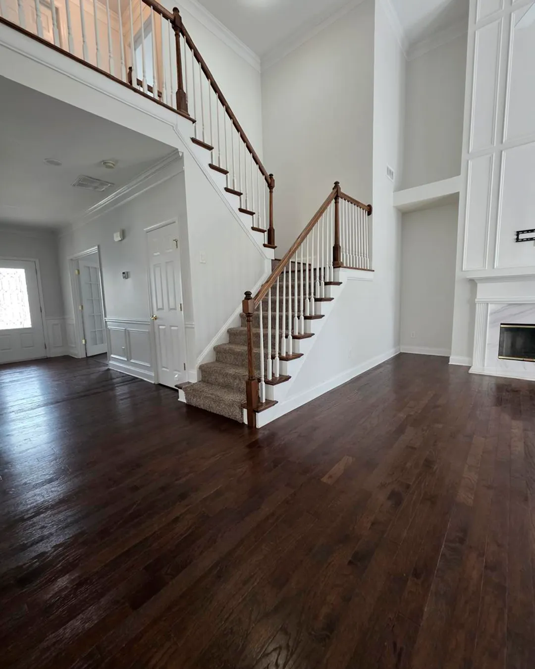 Dark hardwood staircase near a fireplace